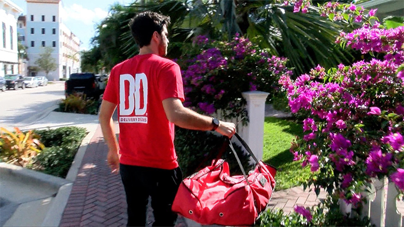 A man from Delivery Dudes service approaching a walkway